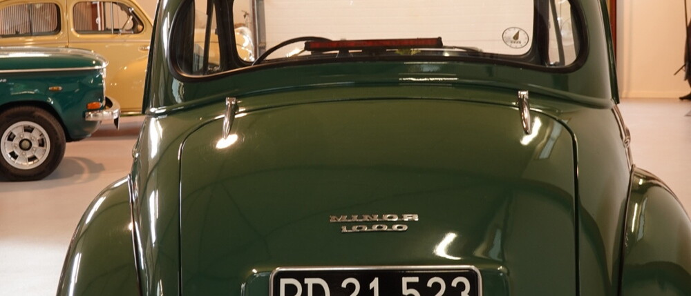 Morris 1000 i showroomet hos Gitz Classic Cars, med andre klassikere i baggrunden